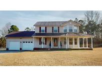 Charming two-story home featuring a spacious front porch and a two-car garage at 96 Overlook Rd, Cameron, NC 28326