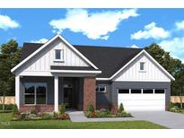 Charming single-story home with a well-manicured lawn, a brick entryway, and an attached two-car garage at 110 Wabash St, Pittsboro, NC 27312