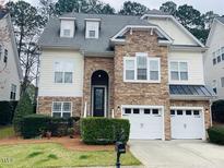 Charming two-story home featuring stone accents, a two-car garage, and well-maintained landscaping at 1100 Dotson Way, Apex, NC 27523