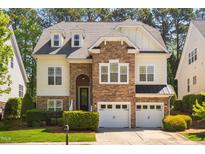 Charming two-story home featuring a stone facade, attached two-car garage, and well-maintained landscaping at 1100 Dotson Way, Apex, NC 27523