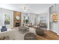 Bright living room with a stone fireplace, hardwood floors, and lots of natural light at 1100 Dotson Way, Apex, NC 27523