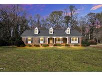 Charming brick home featuring a well-manicured lawn, dormer windows, and an inviting front porch with classic columns at 1192 Princeton Kenly Rd, Kenly, NC 27542