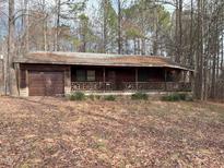 Rustic single-story home featuring a wooden exterior, covered porch, and attached garage at 2408 Homestead Road Rd, Chapel Hill, NC 27516