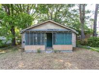 Charming single-story home featuring a screened-in front porch and mature shade trees at 303 Graves St, Selma, NC 27576