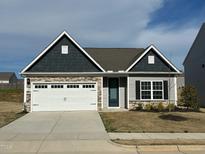 Charming single-Gathering home with a white garage door, stone accents, and gray siding under a cloudy sky at 400 Access Dr, Youngsville, NC 27596