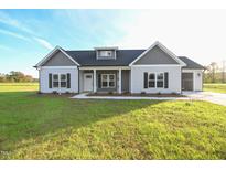 Charming single-story home featuring gray and white siding, black shutters, and a well-manicured lawn at 400 S Eastwood Dr, Benson, NC 27504