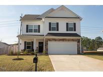 Charming two-story home with stone accents, a two-car garage and a well-manicured front yard at 612 Marian Way, Sanford, NC 27330