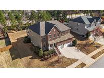 Beautiful two-story brick home featuring an attached two-car garage and manicured landscaping at 705 Prince Dr, Holly Springs, NC 27540