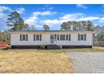Charming single-story home featuring a classic exterior with blue shutters and ample parking at 9817 Holly Springs Rd, Holly Springs, NC 27540