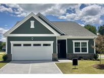 Charming home featuring a well-manicured lawn, a two-car garage, and tasteful exterior color scheme at 100 Big Dream Ct, Louisburg, NC 27549