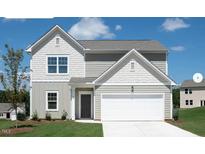 Charming two-story home featuring board and batten and horizontal siding and a two-car garage at 12 Rolling Banks Dr, Louisburg, NC 27549