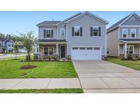 Two-story home featuring gray siding, a two-car garage, and a well-manicured lawn at 1304 Rose Gold Ln, Raleigh, NC 27610