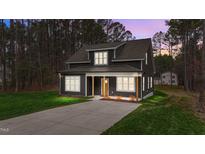 Charming two-story home with dark siding, covered front porch, and well-maintained lawn at 163 Nashua Dr, Louisburg, NC 27549