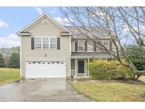 Charming two-story home with a two-car garage and manicured landscaping on a sunny, blue-sky day at 2004 Summer Shire Way, Raleigh, NC 27609