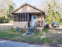 Charming single-story home featuring a screened-in porch and a welcoming front entrance at 207 N Jackson St, Dunn, NC 28334