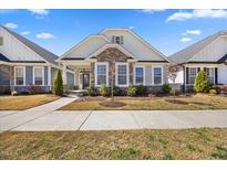 Charming single-story home featuring a stone facade, light siding, manicured lawn, and inviting entrance at 212 Thunder Forest Ln, Wendell, NC 27591