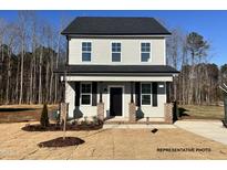 Charming two-story home with gray siding, black shutters, and well-manicured landscaping at 260 Longbow Dr, Middlesex, NC 27557