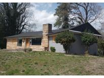 Charming single-story home with a stone facade and mature trees in the front yard at 2602 Fayetteville St, Durham, NC 27707