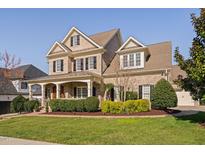 A charming two-story brick home with a welcoming front porch and well-manicured landscaping at 321 Weycroft Grant Dr, Cary, NC 27519