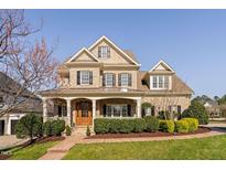 Stunning brick home with a welcoming front porch, manicured landscaping, and classic architectural details at 321 Weycroft Grant Dr, Cary, NC 27519