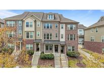 Charming townhomes feature a mix of brick and siding exteriors and inviting front porches at 556 Village Loop Dr, Apex, NC 27502