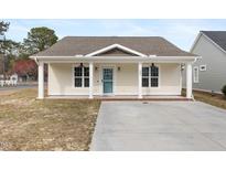 Charming single-story home featuring a covered front porch and a well-maintained yard with new driveway at 600 Cuddington Ln, Nashville, NC 27856