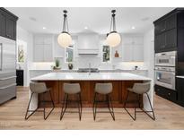 A modern, bright kitchen features a large island with marble countertops and stylish pendant lighting above seating at 604 Edmund St, Raleigh, NC 27604