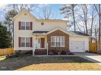 Charming two-story home with a well-manicured lawn and attached garage, perfect for suburban living at 605 Wyndham Dr, Fuquay Varina, NC 27526