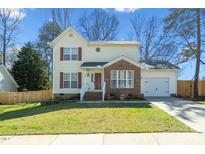 Charming two-story home with red shutters, brick accents, attached garage, and well-maintained lawn at 605 Wyndham Dr, Fuquay Varina, NC 27526