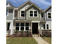 Charming two-story townhome with stone accents, manicured lawn, and welcoming entrance at 6405 Granite Quarry Dr, Raleigh, NC 27610
