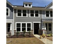 Charming townhouse with stone accents, neutral siding, and bright white-framed windows at 6409 Granite Quarry Dr, Raleigh, NC 27610