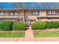 Inviting townhome with a brick walkway, mature landscaping, and a cozy bench at 906 Oak Tree Dr, Chapel Hill, NC 27517