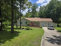 Charming single-story home featuring a well-maintained lawn, quaint shutters, and a cozy front porch at 928 Magnolia Ridge Way, Fuquay Varina, NC 27526