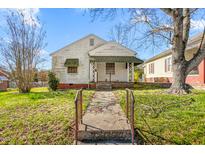 Modest home with a quaint front porch and weathered exterior in need of renovation at 1009 Grace Ave, Burlington, NC 27217