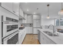 Bright kitchen with white cabinets, stainless steel appliances, and modern pendant lighting at 10210 Sablewood Drive # 112, Raleigh, NC 27617