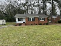 Charming brick home with black shutters, white trim, and a well-maintained lawn at 103 Beam Cir, Louisburg, NC 27549