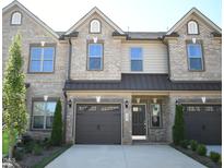 Charming townhome featuring a brick facade, an attached garage, and a well-manicured front yard at 1043 Beechcraft Dr # 120, Mebane, NC 27302