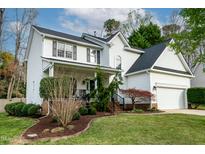 Charming two-story white home with landscaped yard, black shutters, covered porch and attached garage at 113 Running Creek Rd, Cary, NC 27518