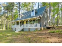 Charming exterior view of home featuring a welcoming front porch and well-maintained lawn at 1301 Flying Hawk Rd, Apex, NC 27523