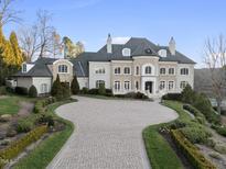 Elegant stone and stucco home features a circular driveway and well-manicured landscaping at 1404 Barony Lake Way, Raleigh, NC 27614
