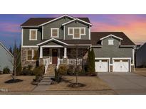 Charming two-story home featuring a stone facade, covered porch, and a two-car garage at 1515 Spring Overlook Ln, Hillsborough, NC 27278