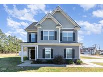 Charming two-story home featuring manicured lawn, beautiful architectural details, and inviting curb appeal at 19 Tobenton Ct, Clayton, NC 27520
