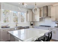 Bright kitchen featuring a white quartz island, stainless steel appliances, and large windows at 2011 Trident Maple Ln, Chapel Hill, NC 27517