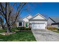 Charming home featuring a well-manicured lawn, two-car garage, and a cheerful green front door at 2021 Heritage Pines Dr, Cary, NC 27519