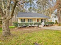Charming single-story home with yellow siding, green shutters, and a cozy front porch at 204 Sugarland Dr, Apex, NC 27502
