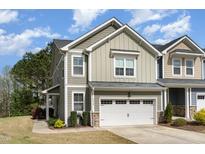 Charming two-story home featuring a gray exterior, attached garage, and well-maintained landscaping at 2418 Pecan Ridge Way, Apex, NC 27502