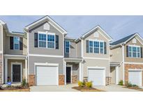 Charming townhome featuring a one car garage, neutral siding, brick accents, and a well manicured front yard at 267 Canopy Dr, Graham, NC 27253