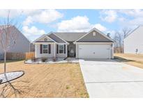 Charming single-story home with neutral siding, manicured landscaping, and attached two-car garage, showcasing curb appeal at 31 Harrow Ter, Roxboro, NC 27574
