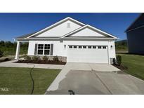 Charming single-story home with white siding, stone accents, and a two-car garage at 380 Pecan Valley Way, Four Oaks, NC 27524