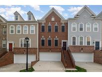 Exterior showcases brick townhomes featuring attached garages, landscaped entrances, and eye-catching architectural details at 4020 Abbey Park Way, Raleigh, NC 27612